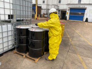 worker and hazardous waste barrels