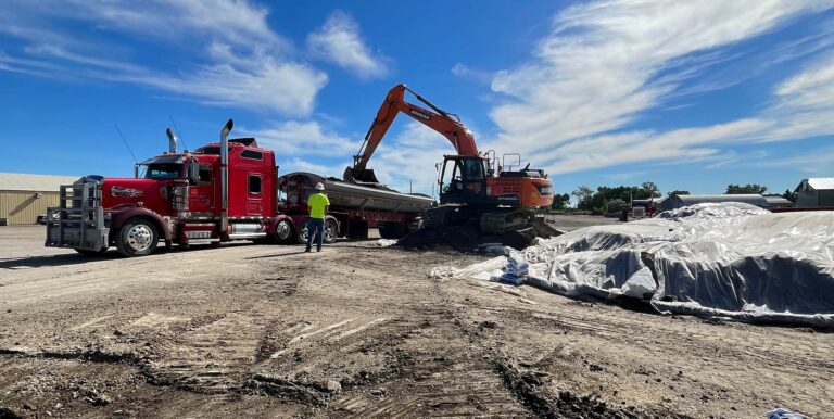 excavator loading dirt onto truck